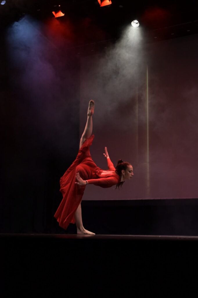 Χορεύτρια με κόκκινο φόρεμα σε arabesque – Σχολή Χορού Χορεύης Πάτρα